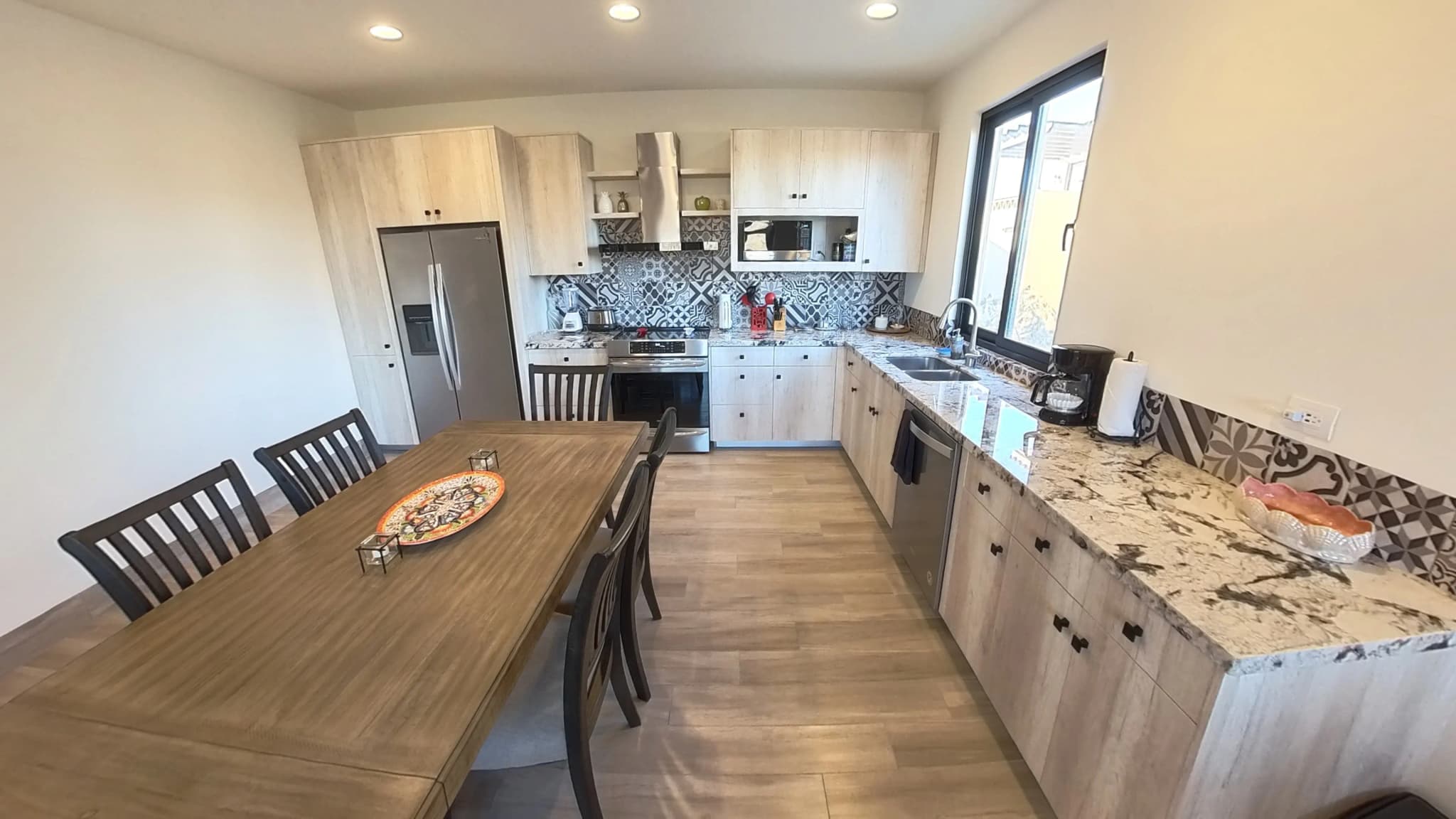 Open kitchen with dining area and wooden furniture in the Mavila 2-bedroom prototype