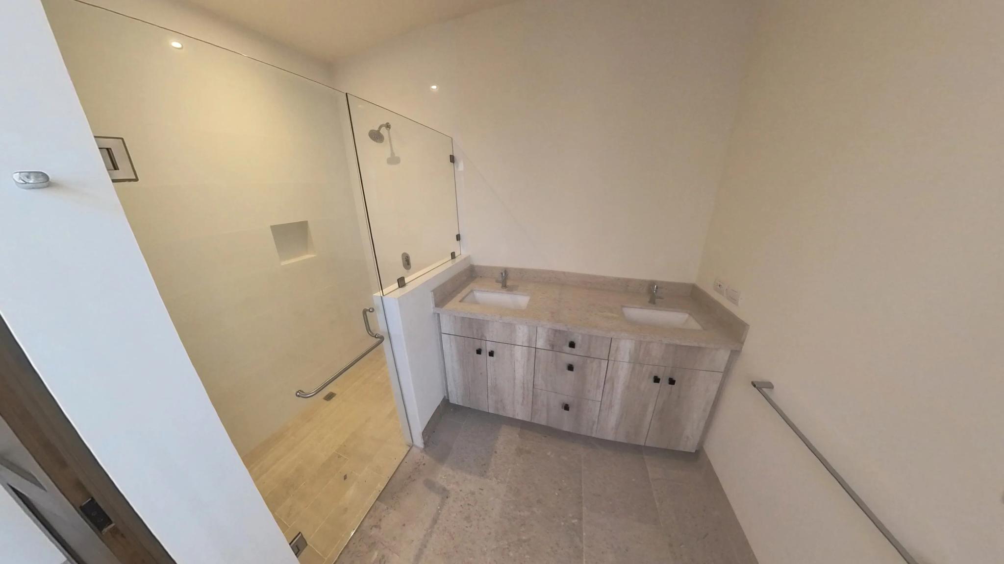 Bathroom with glass shower and single vanity in the Mavila villa prototype